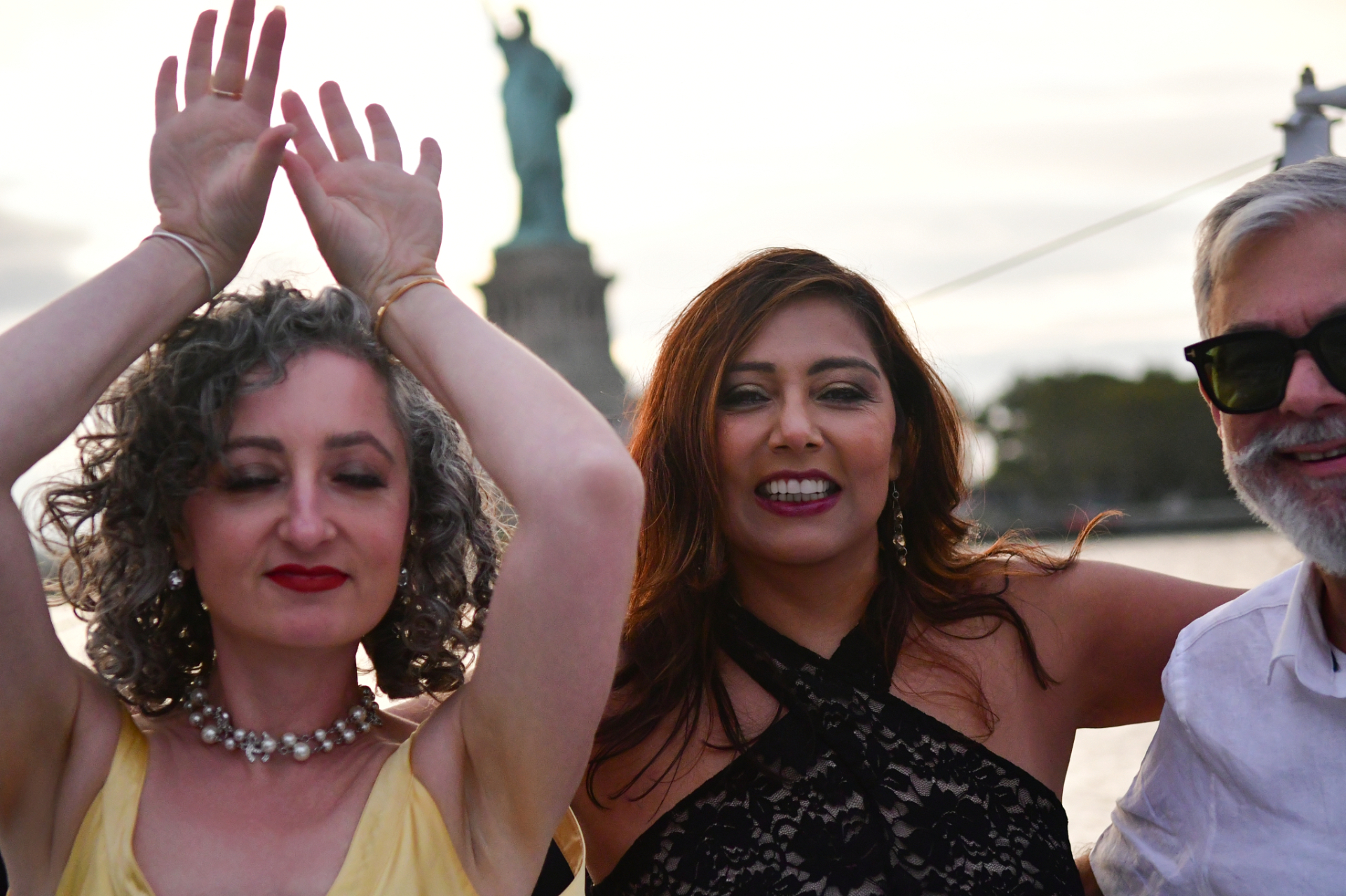 Guests on a NYC event cruise with the Statue of Liberty in the background photographed by Dorothy Shi