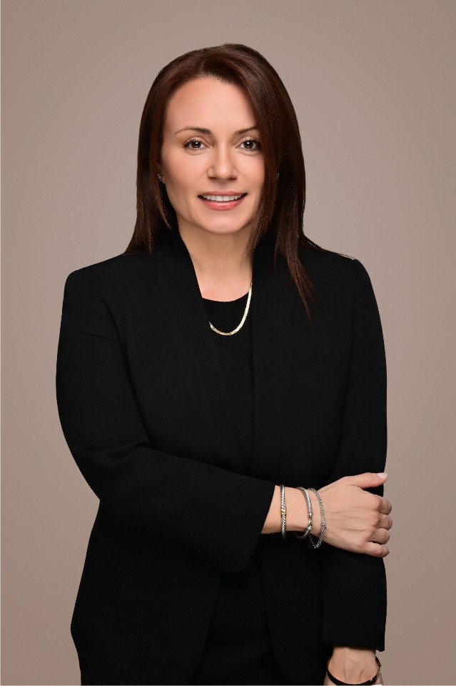 Studio corporate headshot of a woman in a black blazer