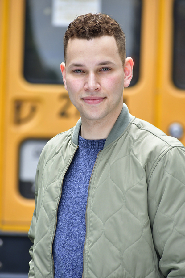 Young male actor headshot in green bomber jacket at NYC subway