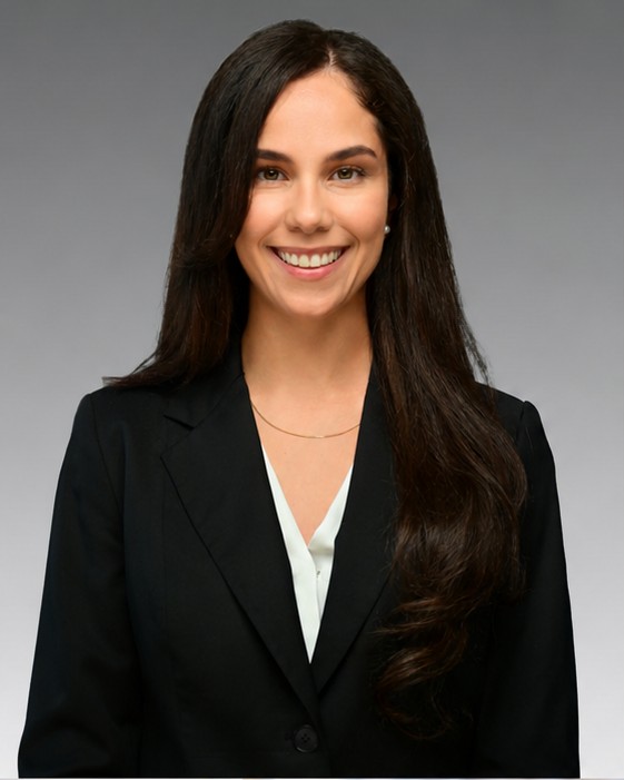 Corporate headshot of a woman in a black blazer with long hair