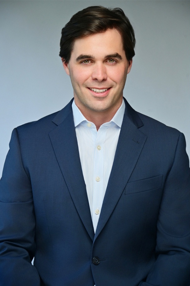Professional LinkedIn headshot of a man in a navy suit